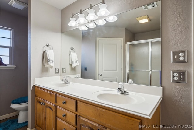 bathroom featuring walk in shower, vanity, and toilet