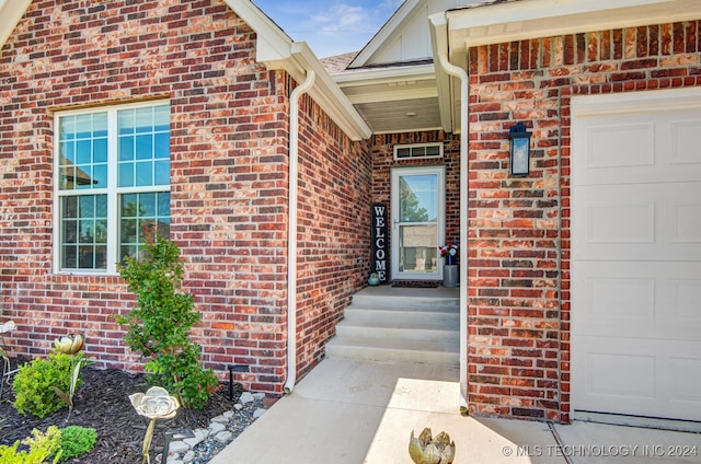 doorway to property with a garage