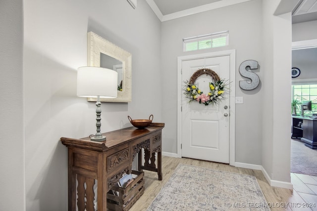 entrance foyer featuring crown molding and light wood-type flooring