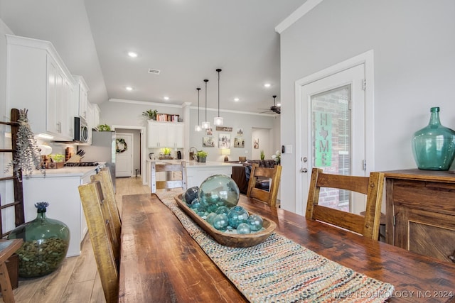 dining room with light hardwood / wood-style flooring, ceiling fan, and ornamental molding