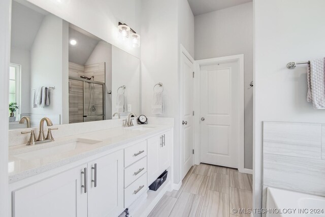 bathroom featuring vanity, vaulted ceiling, and an enclosed shower