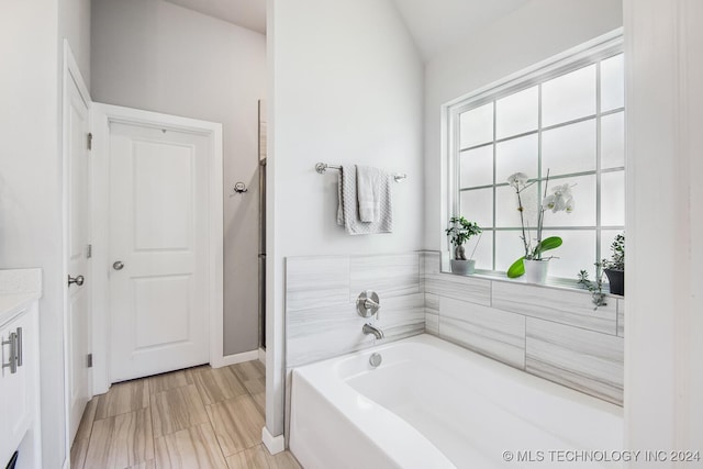 bathroom featuring a bathtub and vaulted ceiling