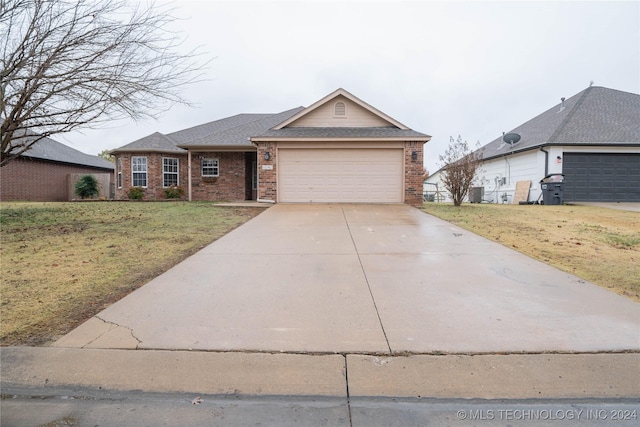 ranch-style home with a garage, a front lawn, and central air condition unit