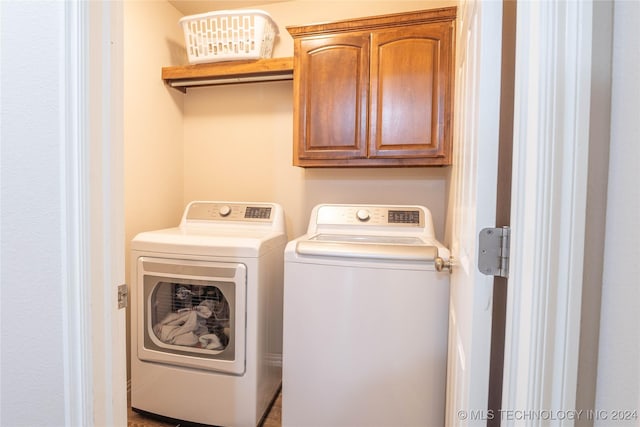 laundry room featuring cabinets and washing machine and clothes dryer