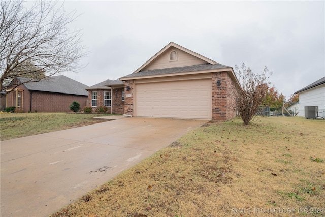 ranch-style house featuring central AC unit, a garage, and a front yard