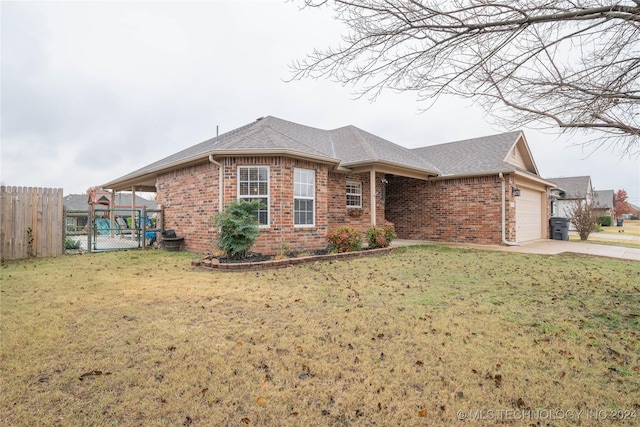 single story home featuring a garage and a front lawn