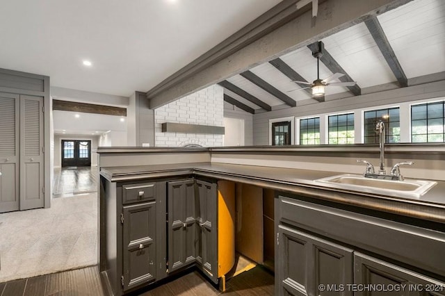 kitchen featuring dark carpet, french doors, sink, vaulted ceiling with beams, and ceiling fan