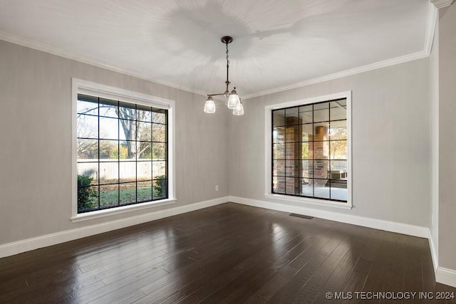 unfurnished dining area featuring dark hardwood / wood-style flooring, ornamental molding, and a chandelier