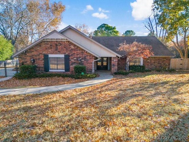 ranch-style house with brick siding, fence, and a front lawn