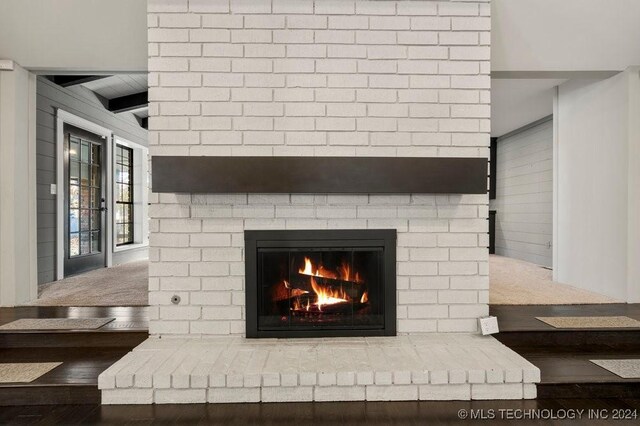 details featuring wood walls, wood-type flooring, and a fireplace