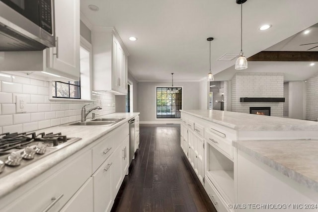 kitchen featuring sink, stainless steel appliances, dark hardwood / wood-style flooring, decorative light fixtures, and white cabinets