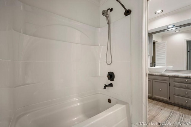 bathroom featuring washtub / shower combination, hardwood / wood-style floors, and vanity