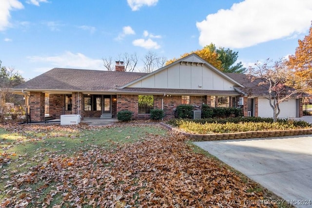 ranch-style house with an attached garage, brick siding, roof with shingles, board and batten siding, and a chimney