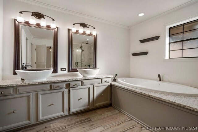 bathroom with hardwood / wood-style floors, vanity, crown molding, and independent shower and bath