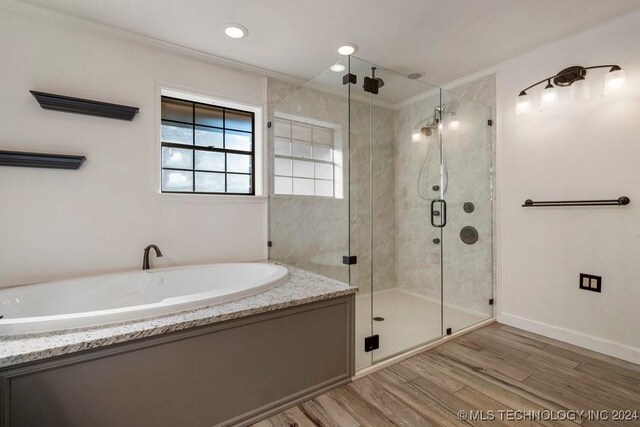 bathroom featuring hardwood / wood-style floors, crown molding, and plus walk in shower