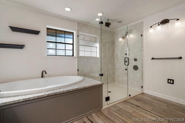 full bathroom with a stall shower, ornamental molding, a garden tub, and wood finished floors