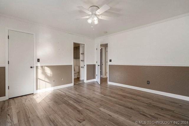 spare room featuring hardwood / wood-style flooring, ceiling fan, and crown molding