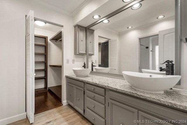 bathroom featuring crown molding, hardwood / wood-style floors, and vanity