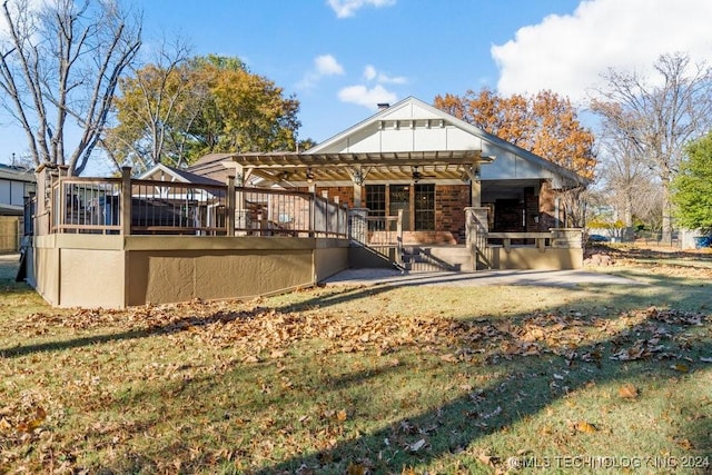 rear view of house with brick siding, a yard, a wooden deck, and a pergola