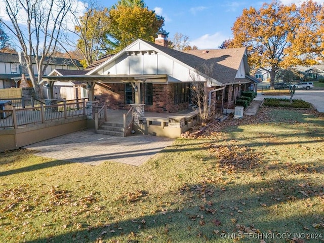 rear view of house featuring a porch, a patio area, and a lawn