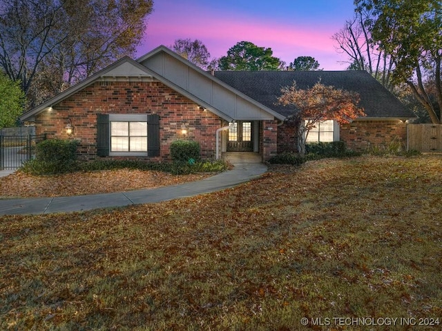 view of front of property with brick siding and fence