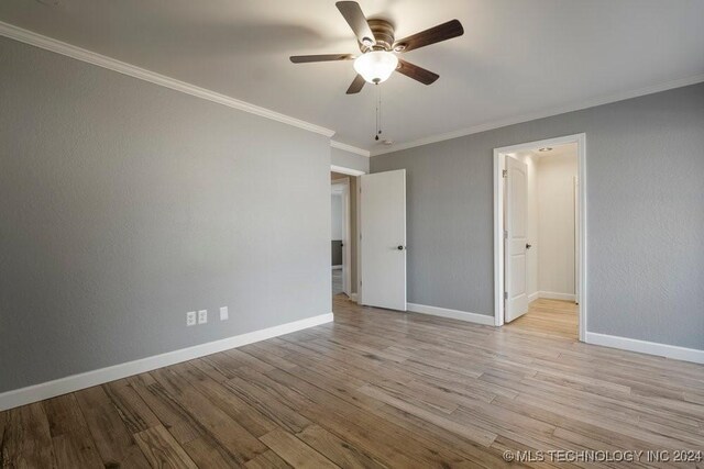 spare room with light wood-style floors, baseboards, ornamental molding, and ceiling fan