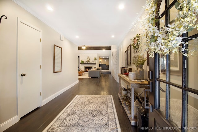 corridor with dark wood-style floors, ornamental molding, recessed lighting, and baseboards