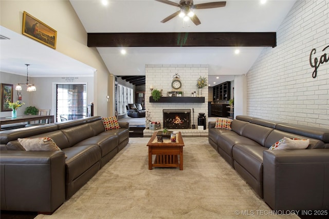 living area with light colored carpet, brick wall, vaulted ceiling with beams, a brick fireplace, and ceiling fan with notable chandelier