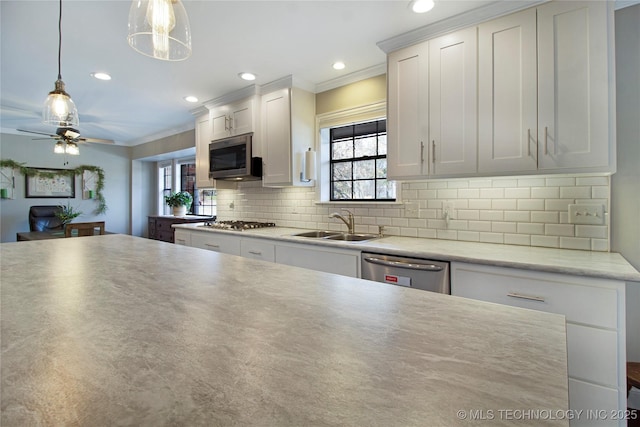 kitchen featuring light countertops, appliances with stainless steel finishes, white cabinetry, and decorative light fixtures