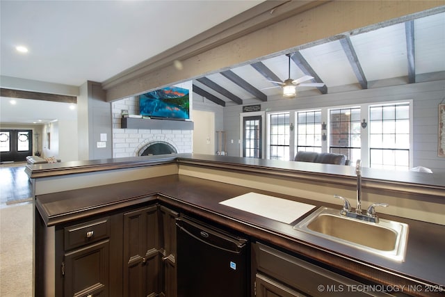 kitchen with lofted ceiling with beams, a sink, open floor plan, a brick fireplace, and dishwasher