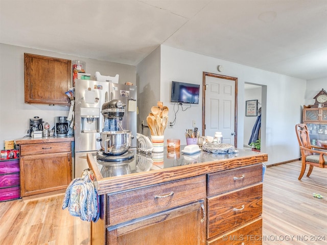 kitchen featuring stainless steel fridge and light hardwood / wood-style flooring