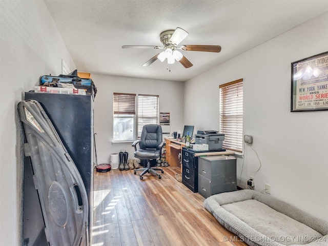 office area with ceiling fan, plenty of natural light, hardwood / wood-style floors, and a textured ceiling