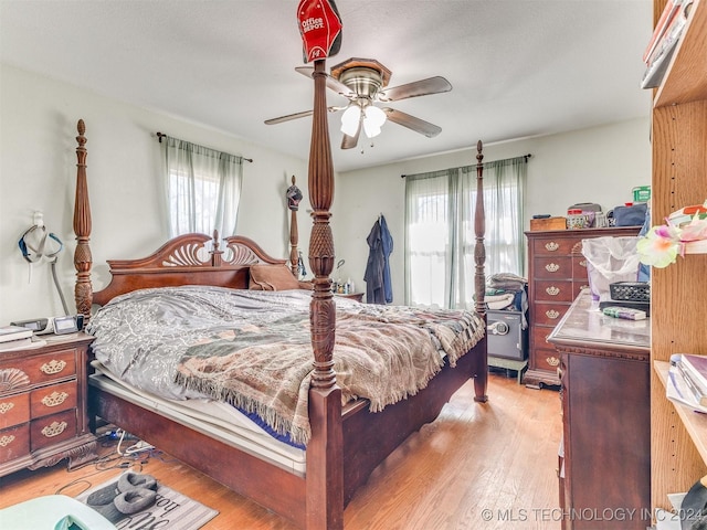 bedroom with light hardwood / wood-style floors, multiple windows, and ceiling fan