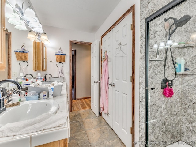 full bathroom featuring a sink, a shower stall, and double vanity