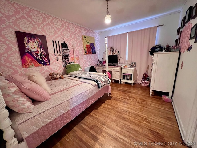 bedroom with wood-type flooring and crown molding