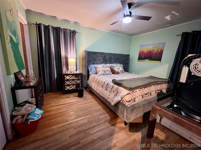 bedroom featuring ceiling fan, hardwood / wood-style floors, and crown molding