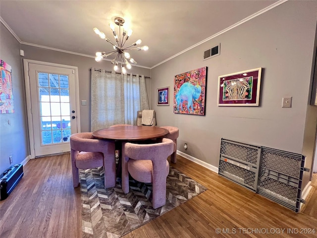 dining space with hardwood / wood-style floors, a chandelier, and ornamental molding