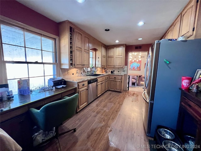 kitchen featuring light brown cabinets, sink, light hardwood / wood-style flooring, appliances with stainless steel finishes, and tasteful backsplash