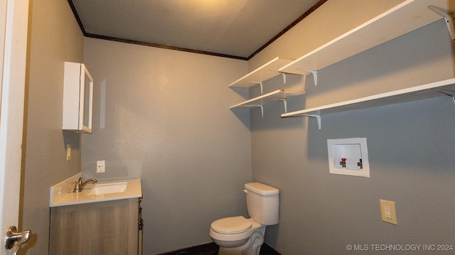 bathroom with a textured ceiling, vanity, toilet, and crown molding