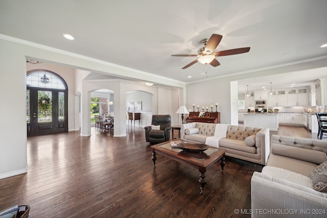 living room featuring crown molding, ceiling fan, and dark hardwood / wood-style flooring