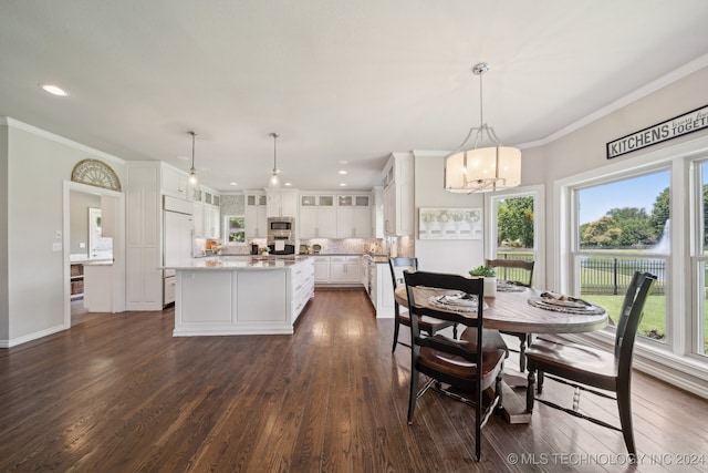 dining area with dark hardwood / wood-style flooring, plenty of natural light, ornamental molding, and a chandelier