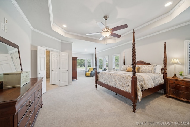 carpeted bedroom featuring ceiling fan, ornamental molding, and a tray ceiling