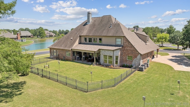 rear view of property with a water view, central AC, a patio area, and a lawn