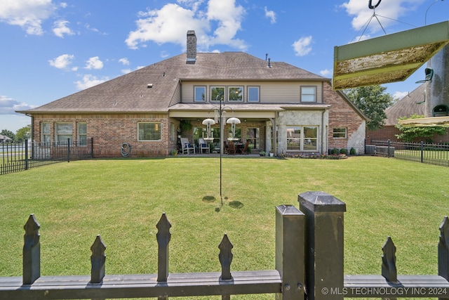 back of house with a lawn