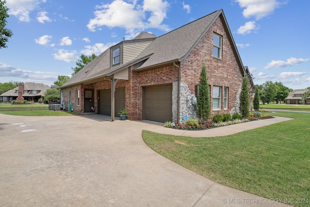 view of front facade with a garage, central AC unit, and a front yard