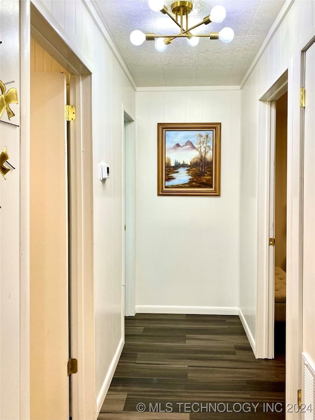 hallway featuring a textured ceiling, crown molding, a chandelier, and dark hardwood / wood-style floors