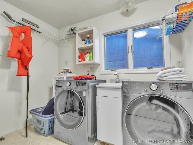 washroom with washer and clothes dryer and cabinets