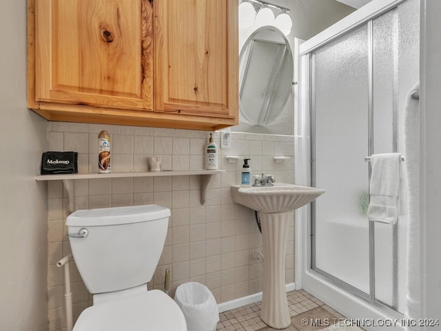 bathroom with tile patterned flooring, decorative backsplash, toilet, and a shower with door