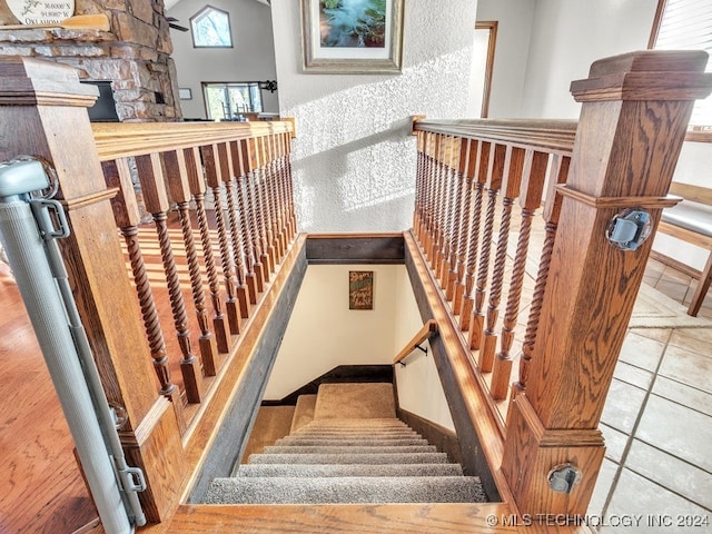 staircase with a fireplace and tile patterned flooring