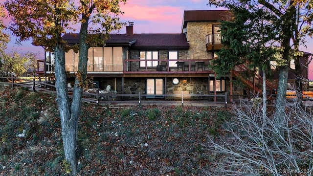 back house at dusk with a balcony